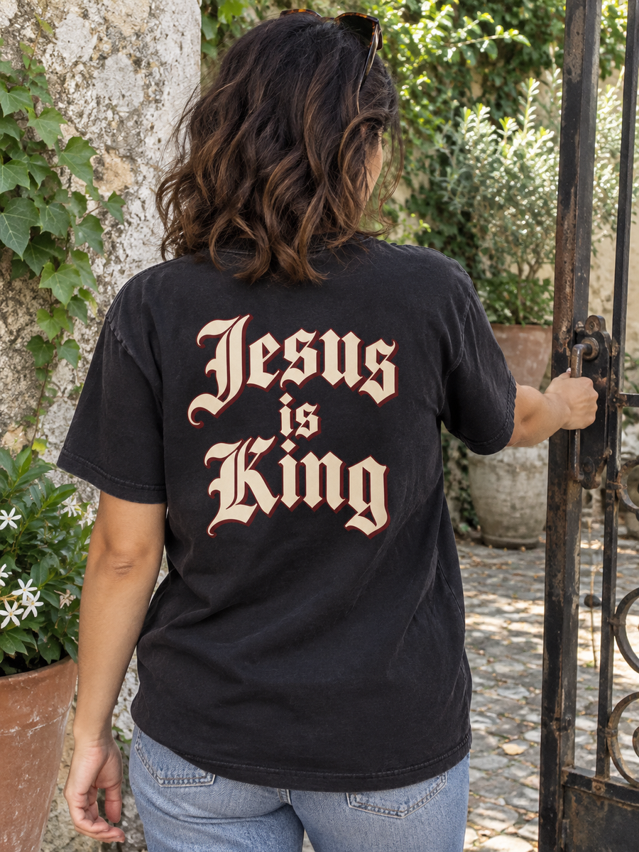 Jesus Is King Royal Lettering black tee — slider back courtyard