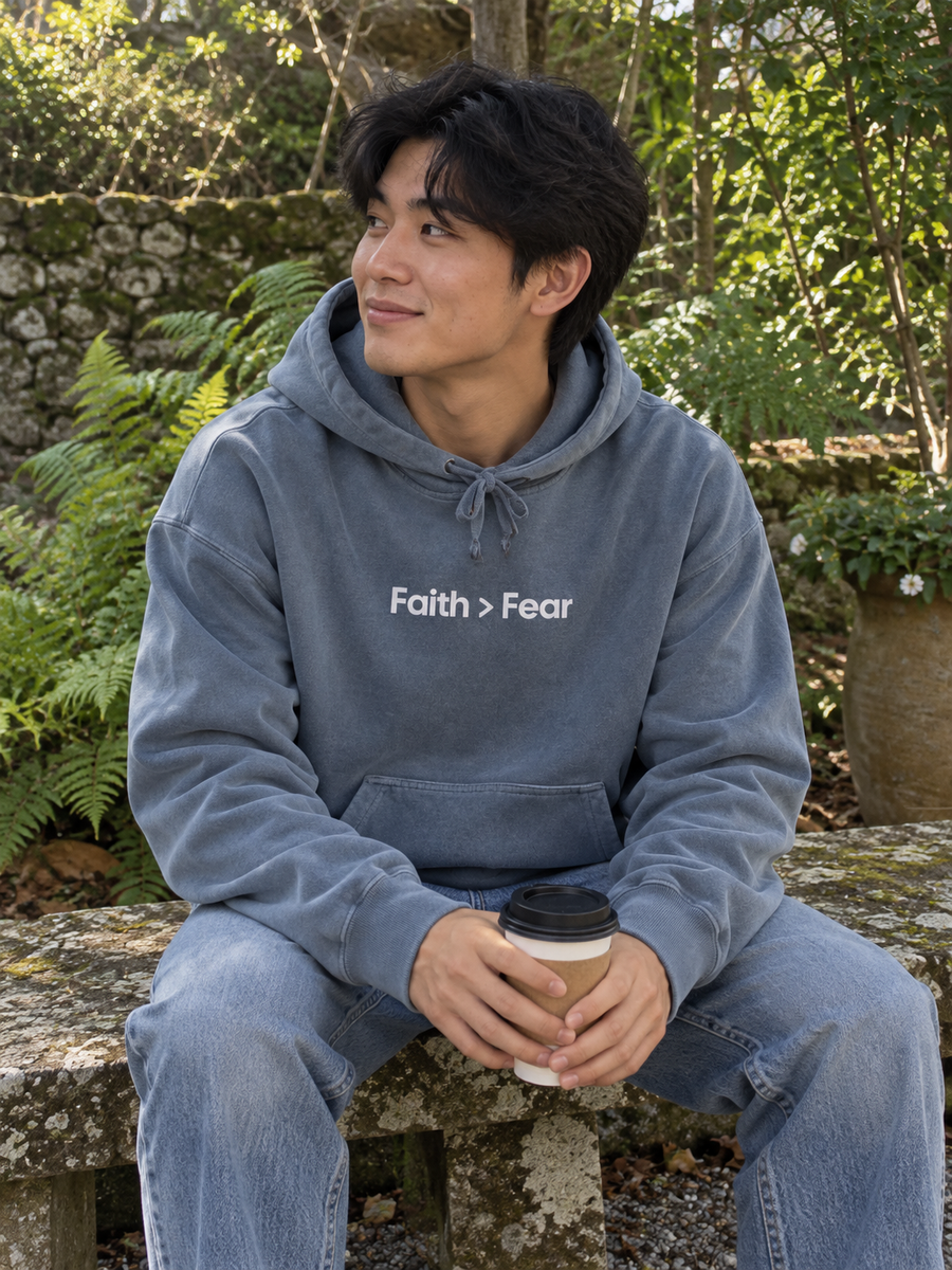 Faith > Fear Unisex Pigment-Dyed Hoodie Sweatshirt — Man with coffee on stone garden bench