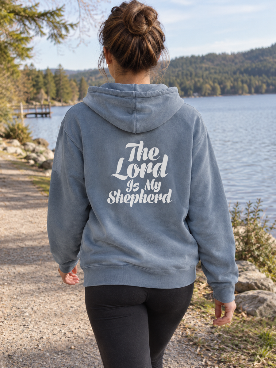 Psalm 23:1 Unisex Pigment-Dyed Hoodie Sweatshirt — Woman walking lake path, back print visible