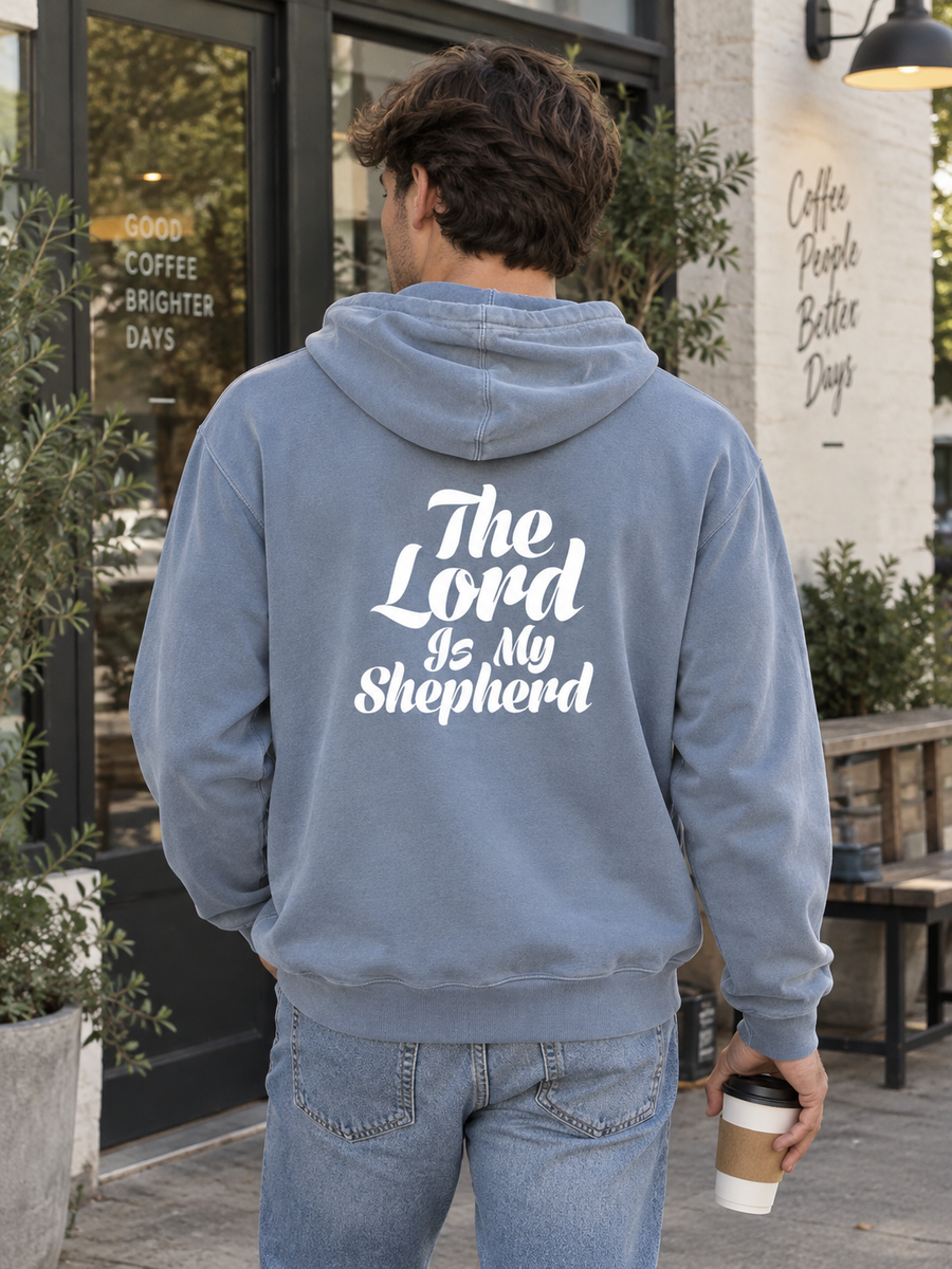 Psalm 23:1 Unisex Pigment-Dyed Hoodie Sweatshirt — Man holding coffee outside café, back print visible