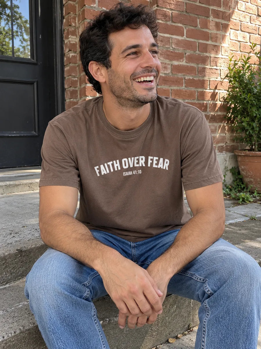 AI-created scene of a man in the brown Faith Over Fear tee sitting on brick courtyard steps