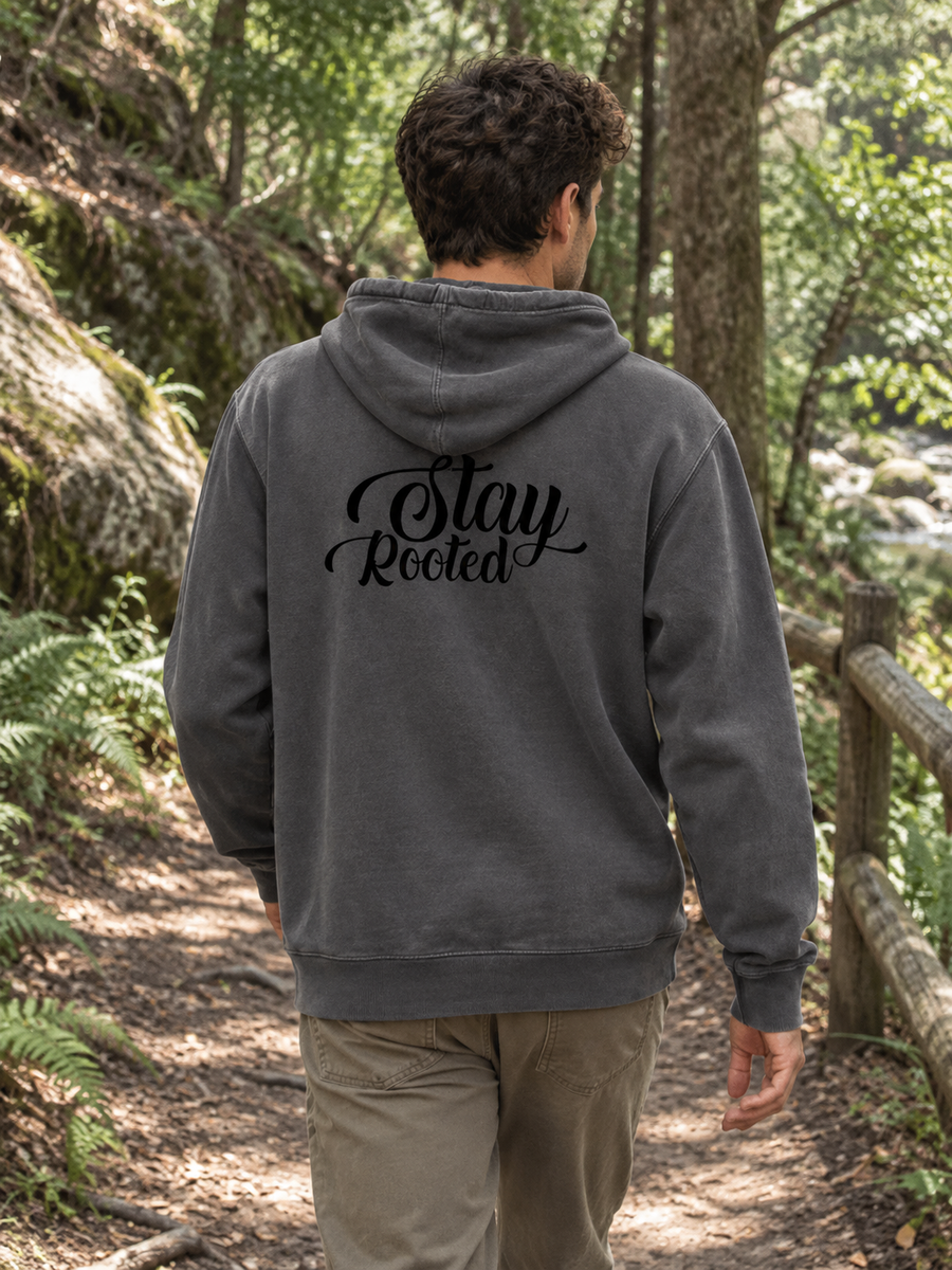 Stay Rooted Unisex Pigment-Dyed Hoodie Sweatshirt — Man walking forest path, back print visible