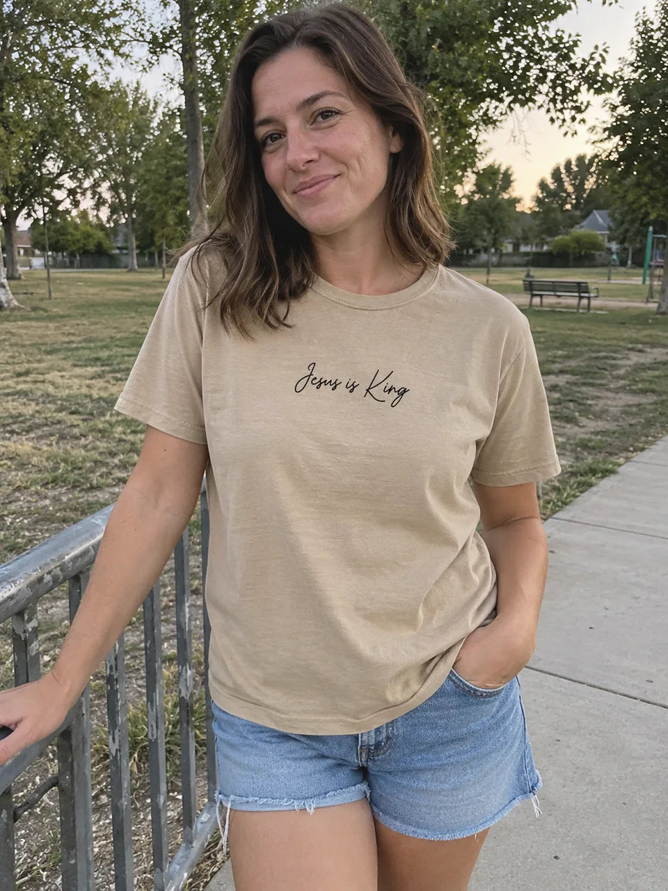 Khaki Jesus Is King tee styled with denim at the park