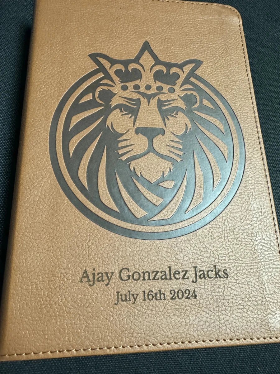 Brown Bible with a crowned lion, Ajay Gonzalez Jacks and July 16th 2024 engraved on its cover