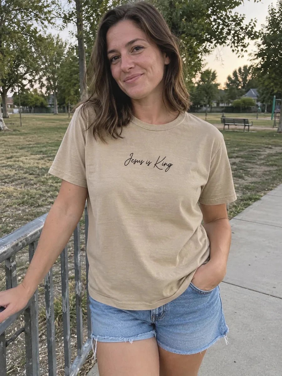 Khaki Jesus Is King tee styled with denim at the park